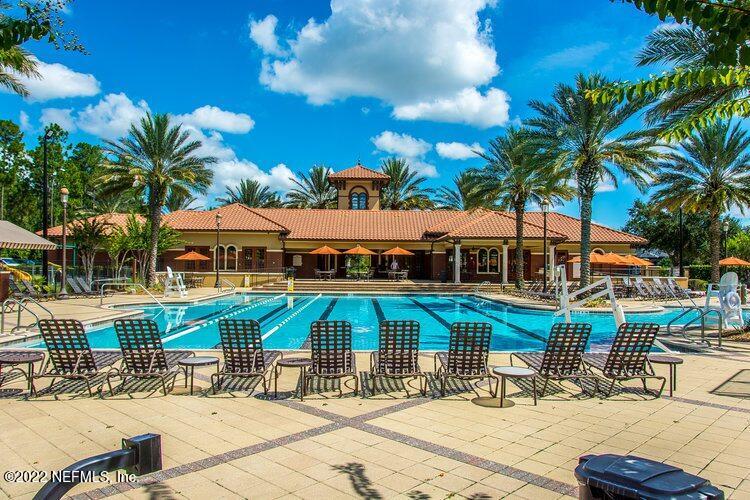 552 Richmond Drive St. Johns, FL 32259 - Photo 49 of 50 a patio with a table and chairs under an umbrella