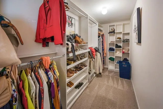 a view of walk in closet with clothes