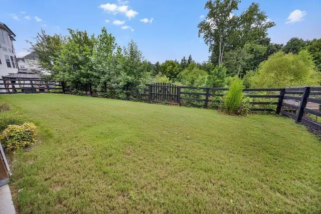 a view of a green field with wooden fence