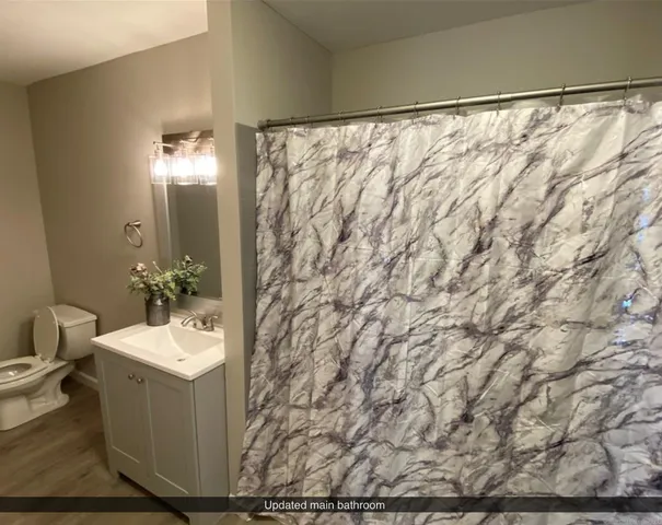 a bathroom with a sink and mirror with toilet