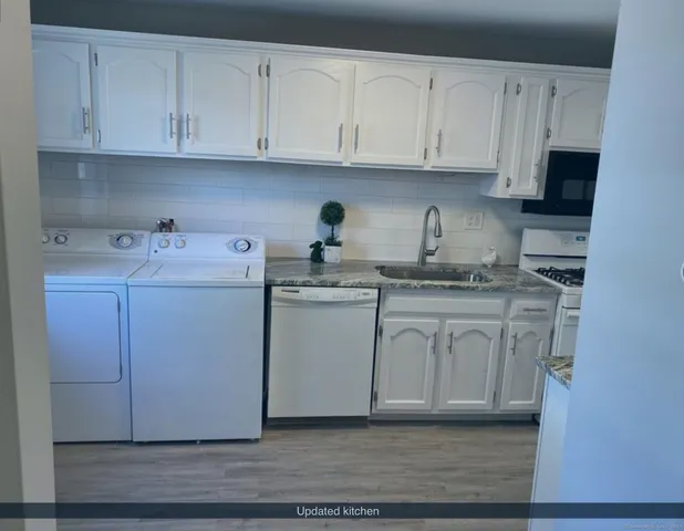a view of cabinets a sink and dishwasher in a white cabinet