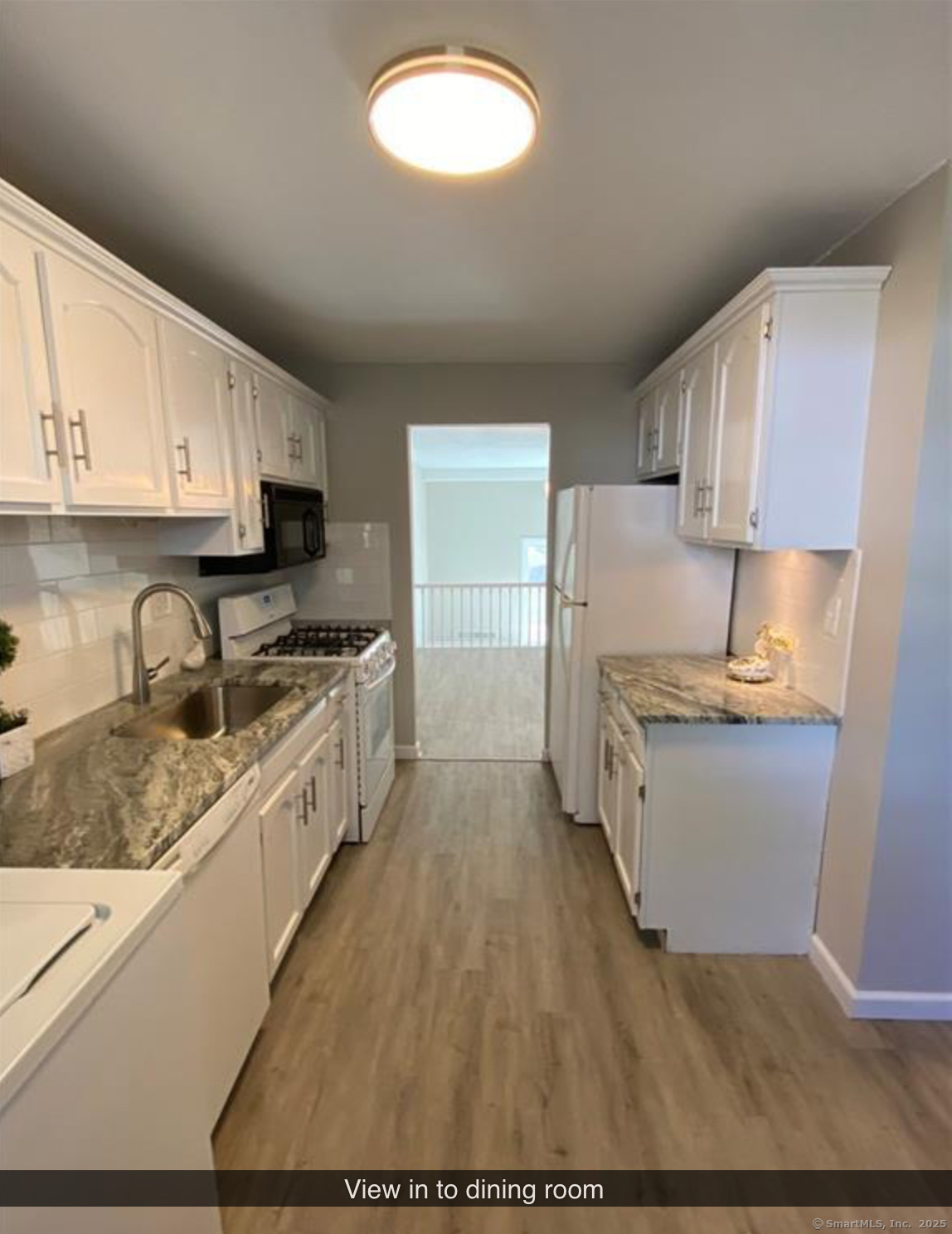 99 Brittany Farms Road, Unit F New Britain, CT 06053 - Photo 6 of 31 a kitchen with sink a microwave and cabinets