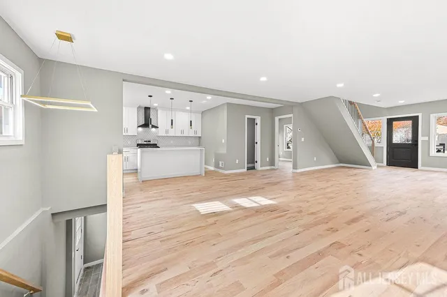 a kitchen with stainless steel appliances kitchen island granite countertop a stove a sink and white cabinets