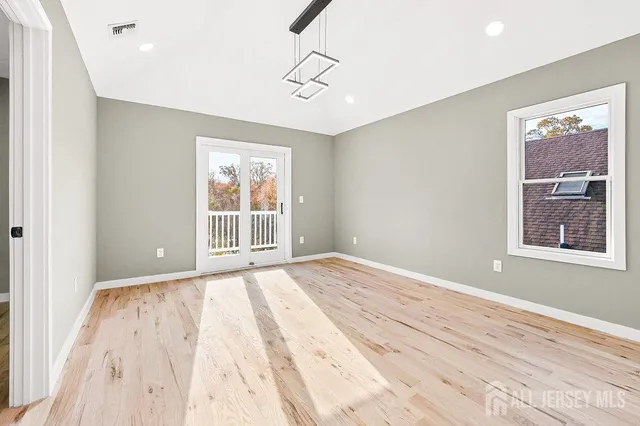 a view of a big room with wooden floor and windows