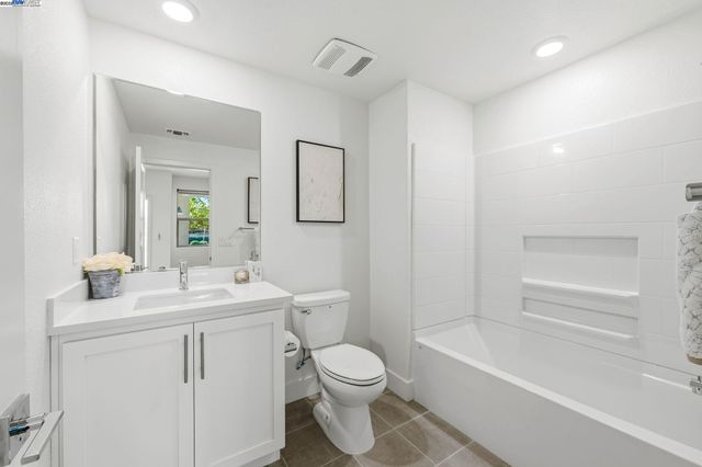 a bathroom with a toilet a bath tub a sink and mirror