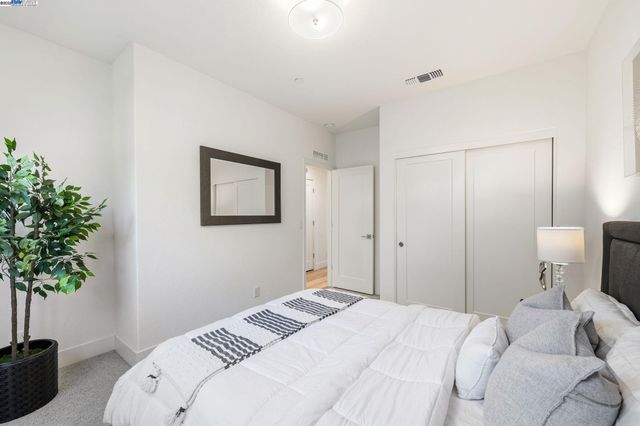 a bedroom with a bed and a potted plant