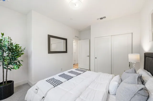 a bedroom with a bed and a potted plant