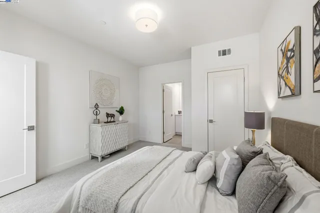 a bedroom with a white bed and a cabinets