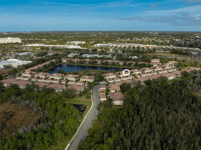 an aerial view of ocean and residential houses with outdoor space