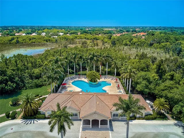 an aerial view of a house with a yard and trees all around