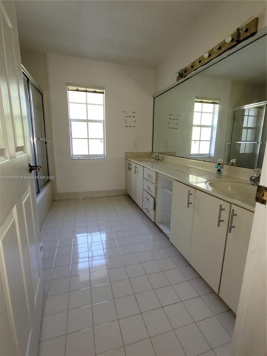 14830 Southwest 149th Street Miami, FL 33196 - Photo 21 of 25 a bathroom with a sink a toilet and mirror