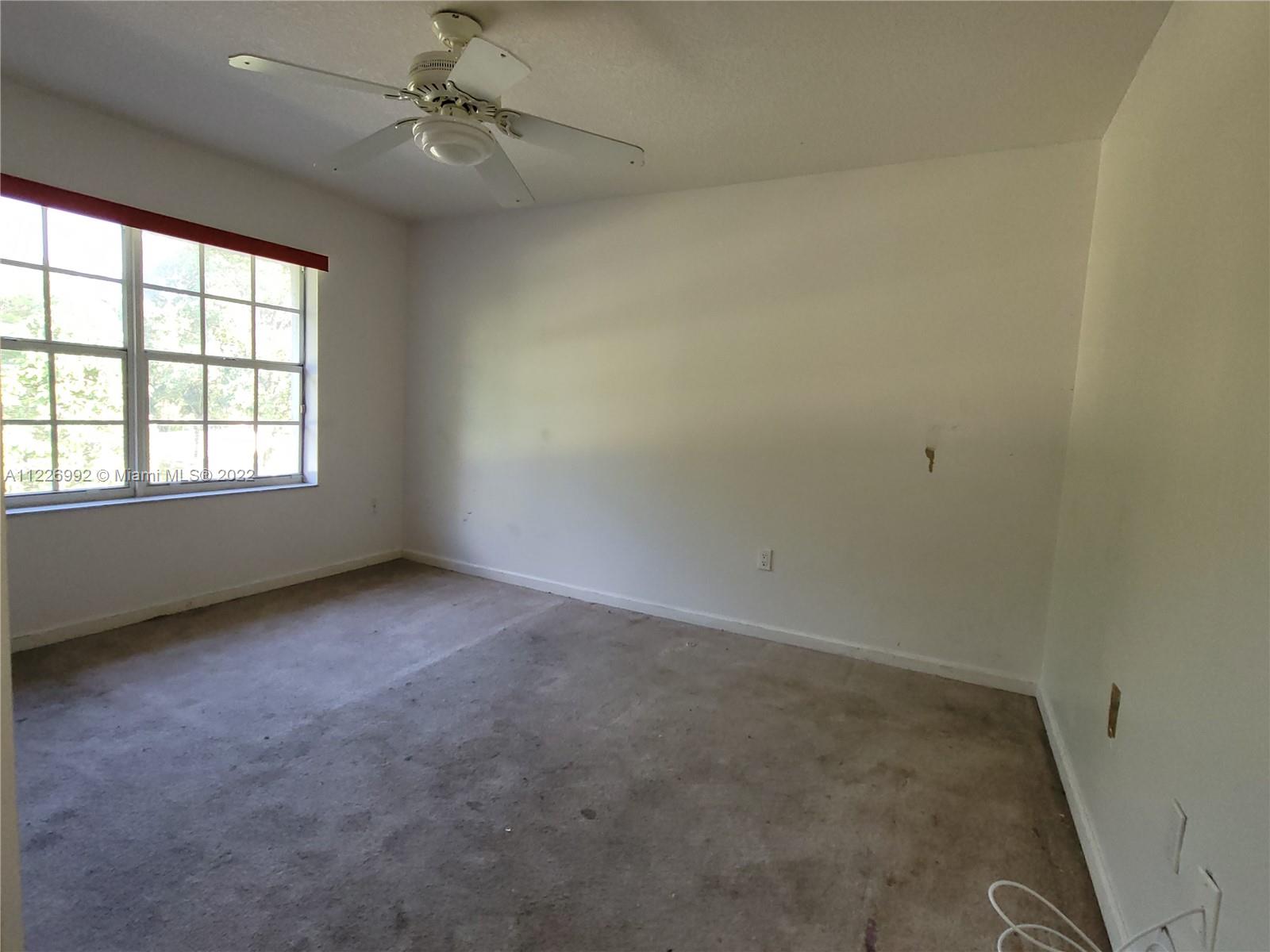 14830 Southwest 149th Street Miami, FL 33196 - Photo 22 of 25 an empty room with a window and ceiling fan