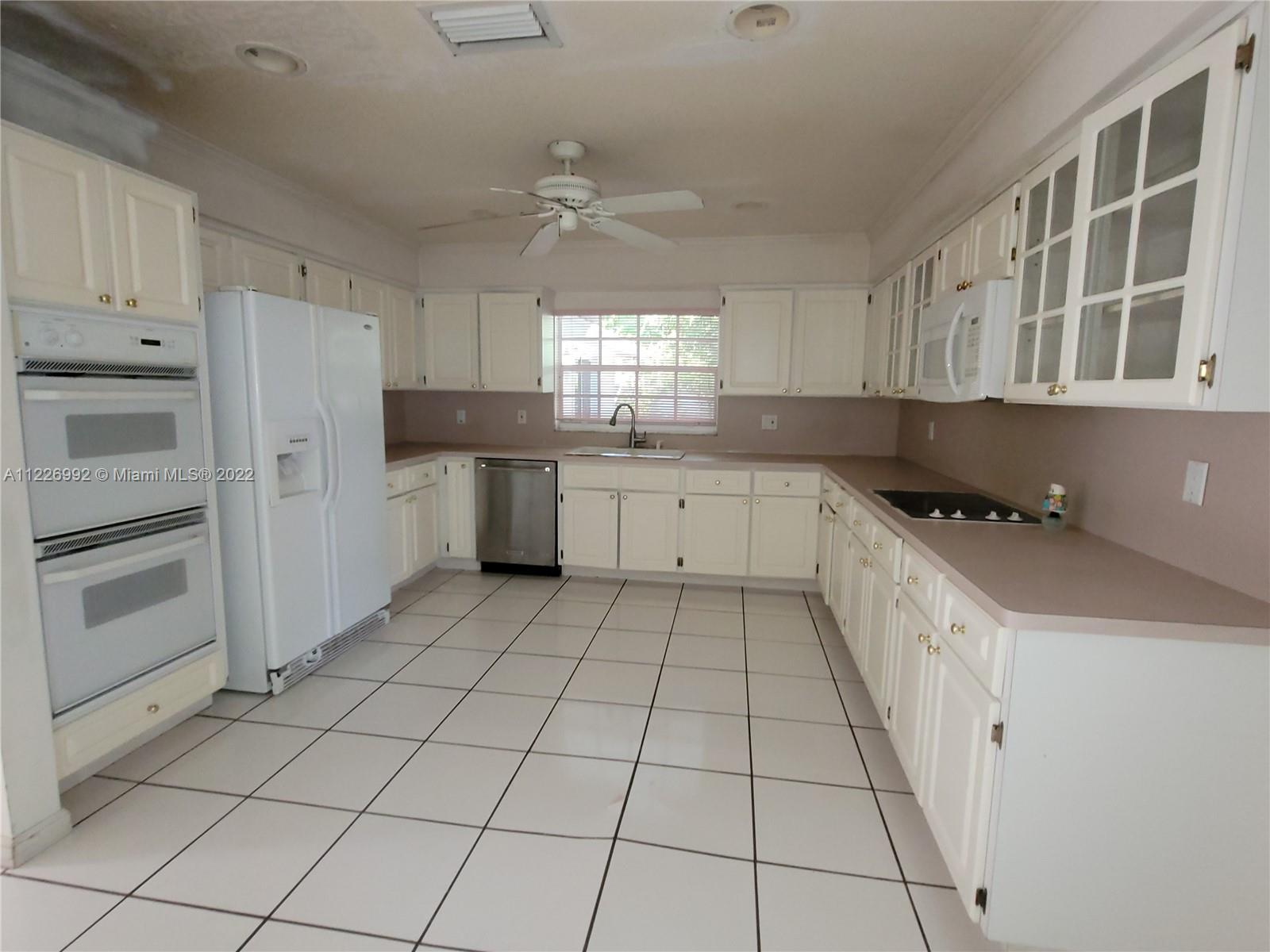 14830 Southwest 149th Street Miami, FL 33196 - Photo 5 of 25 a kitchen with a stove a sink and a refrigerator
