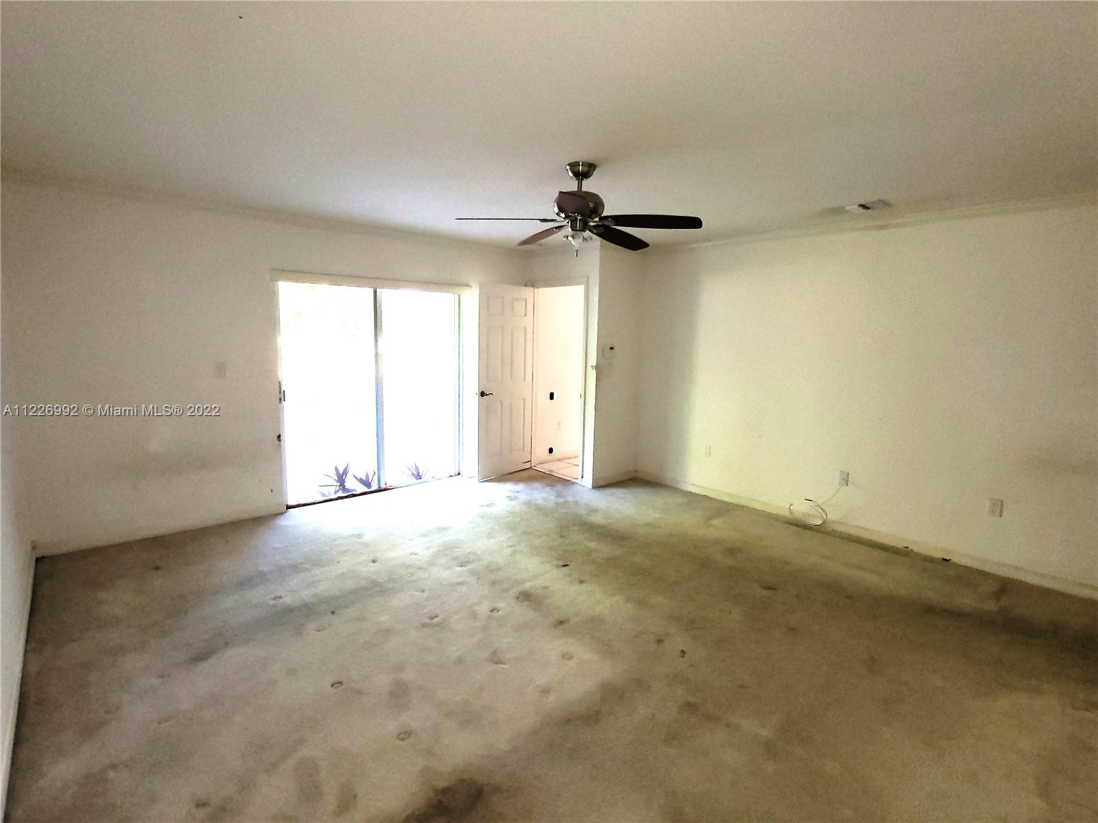14830 Southwest 149th Street Miami, FL 33196 - Photo 7 of 25 an empty room with a window and a ceiling fan