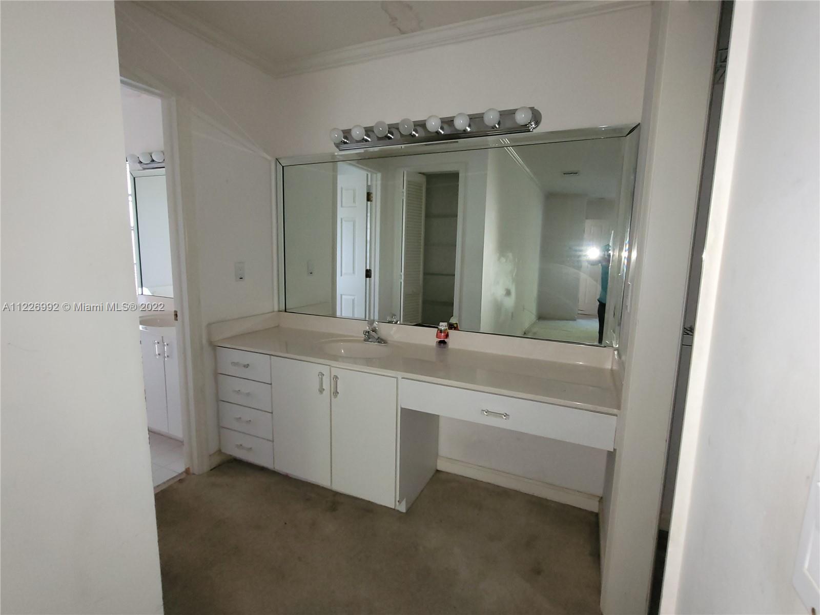 14830 Southwest 149th Street Miami, FL 33196 - Photo 8 of 25 a bathroom with a granite countertop sink a mirror and a bathtub