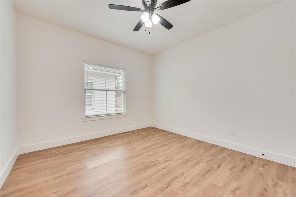 1807 Franklin Street Bonham, TX 75418 - Photo 5 of 13 an empty room with wooden floor chandelier fan and windows