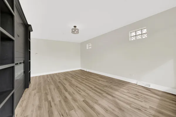a view of empty room with wooden floor