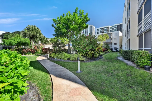 a view of a garden with a building in the background
