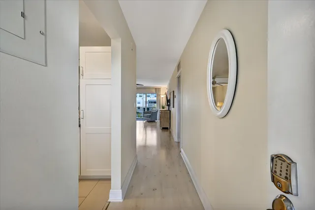 a view of a hallway with wooden floor door and windows