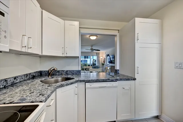 a kitchen with white cabinets and a sink