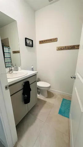 a utility room with a sink a toilet and a mirror