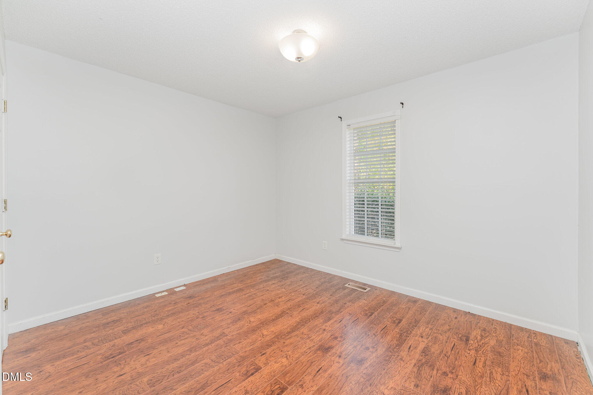 687 West Watson Road Benson, NC 27504 - Photo 13 of 25 an empty room with wooden floor and windows