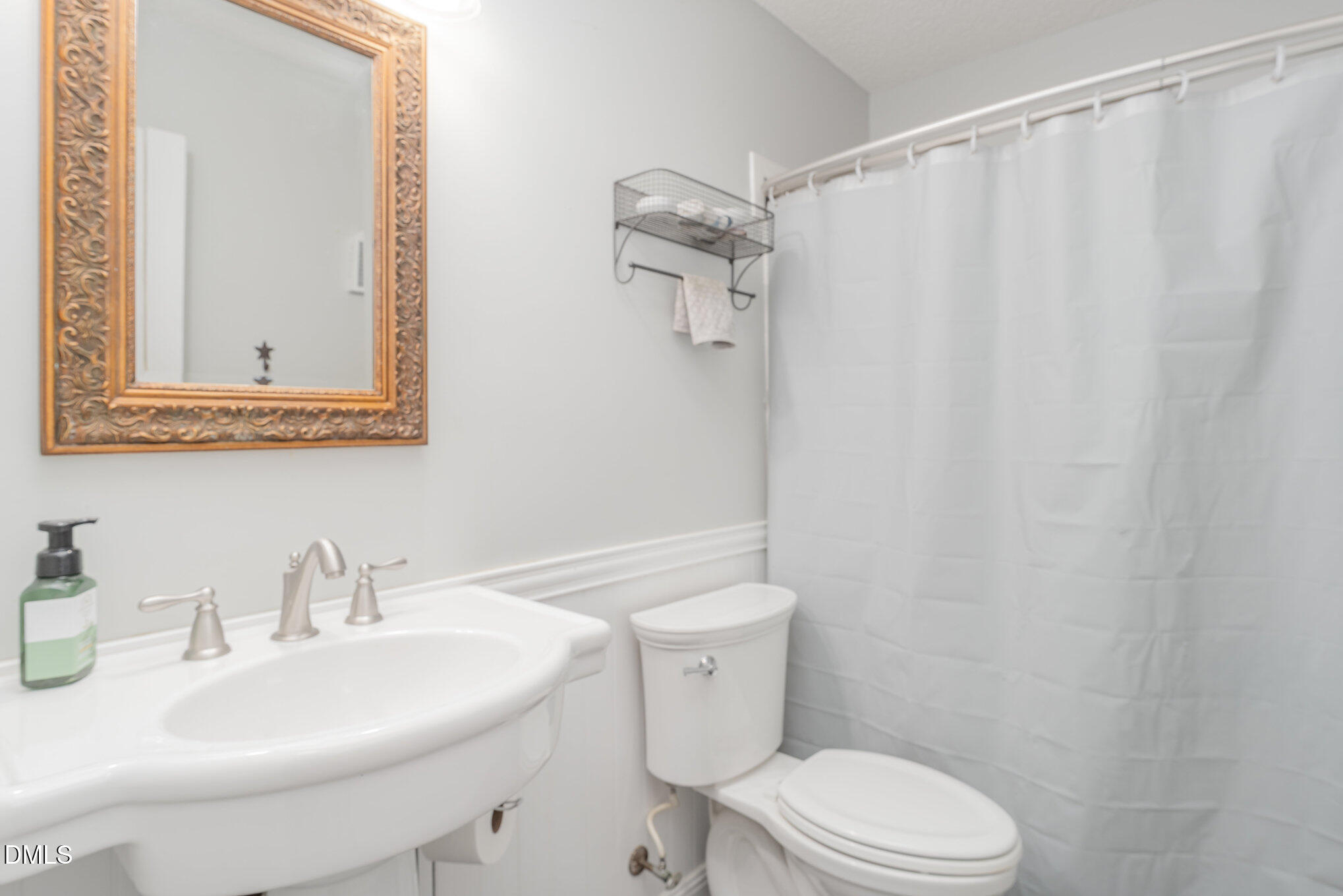 687 West Watson Road Benson, NC 27504 - Photo 14 of 25 a bathroom with a sink a toilet and shower curtain