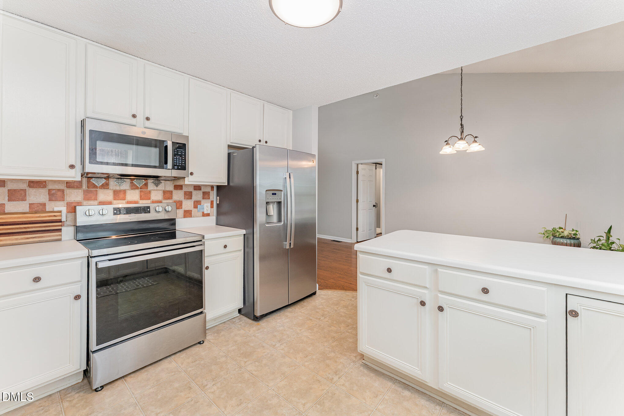 687 West Watson Road Benson, NC 27504 - Photo 9 of 25 a kitchen with white cabinets and stainless steel appliances