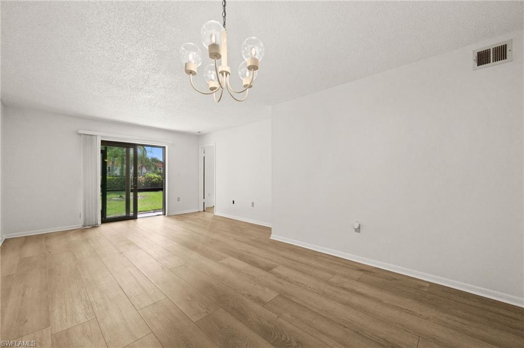 4251 27th Court Southwest, Unit 104 Naples, FL 34116 - Photo 4 of 22 a view of an empty room with wooden floor and a window