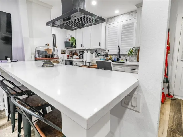 a kitchen with a sink a stove and chairs