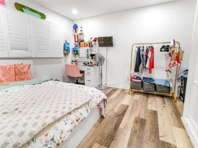 a bedroom with a bed and wooden floor