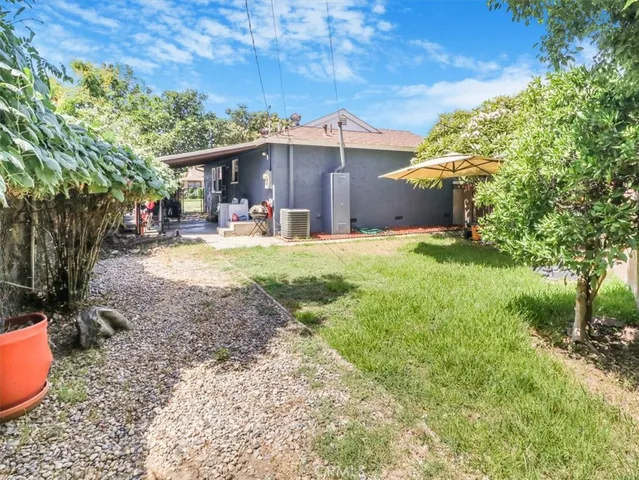 a view of a house with backyard and sitting area