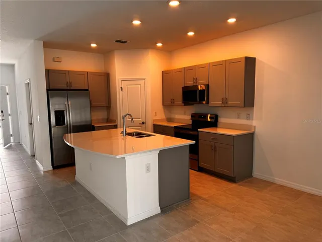 a kitchen with stainless steel appliances a sink stove and refrigerator