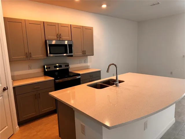 a kitchen with stainless steel appliances a microwave sink and cabinets