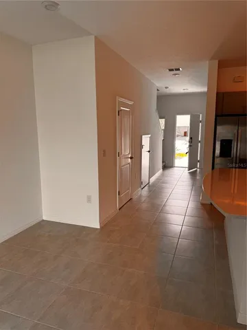 a view of a hallway with wooden floor and a living room
