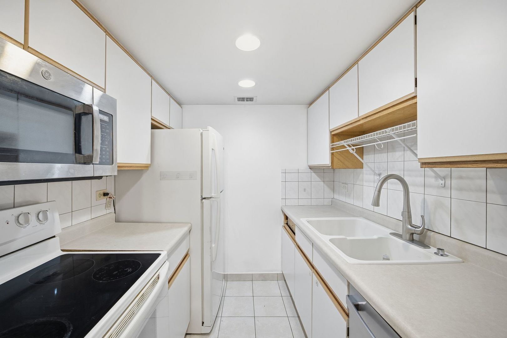 4618 River Road, Unit 1D Schiller Park, IL 60176 - Photo 7 of 12 a kitchen with stainless steel appliances granite countertop a sink stove and refrigerator