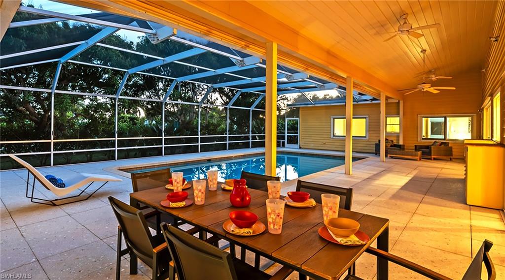 586 Yucca Road Naples, FL 34102 - Photo 23 of 26 Swimming pool with a lanai, a patio, a sunroom, an outdoor hangout area, and outdoor dining area