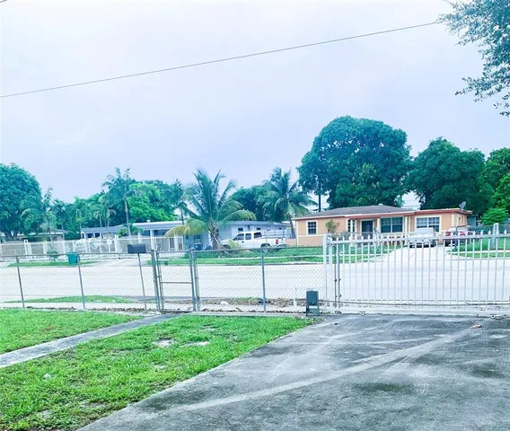 a view of a house with a yard and a fence