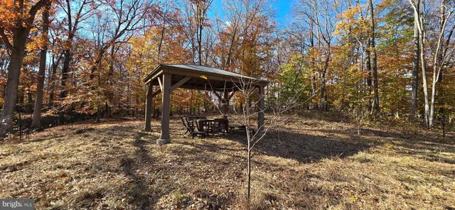 a view of a wooden bench sitting in the middle of a yard