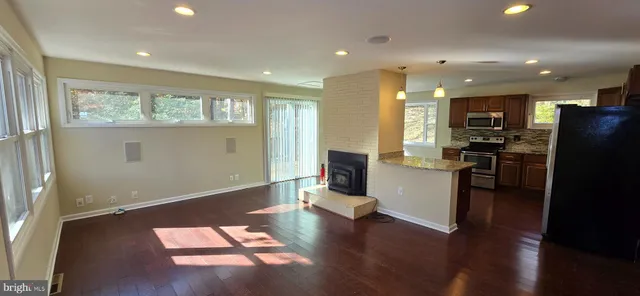 a view of a kitchen with refrigerator and wooden floor