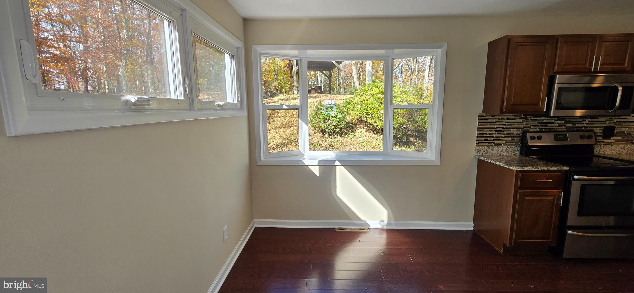 7613 Locust Lane Fort Washington, MD 20744 - Photo 19 of 49 a view of an empty room with wooden floor and a window