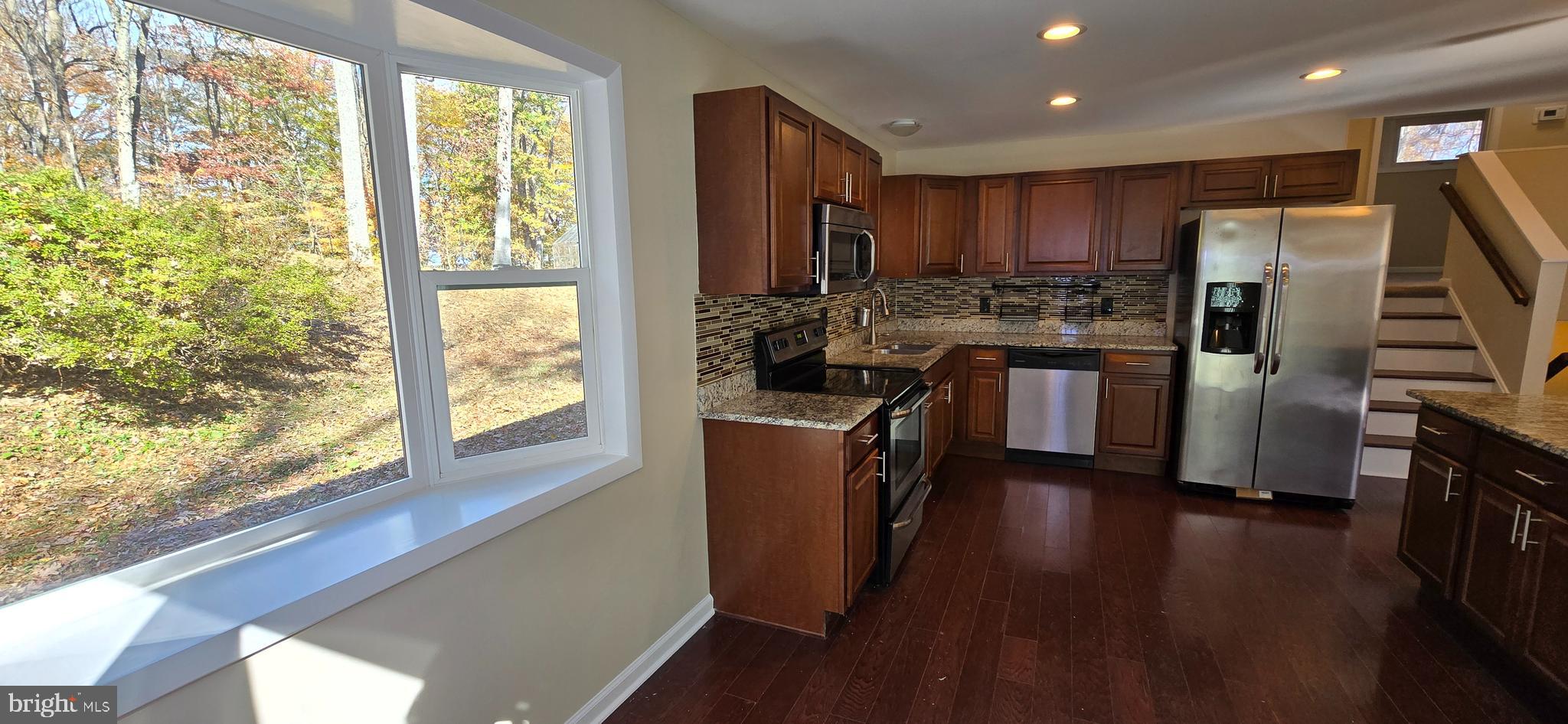 7613 Locust Lane Fort Washington, MD 20744 - Photo 21 of 49 a kitchen with refrigerator a stove and wooden floor