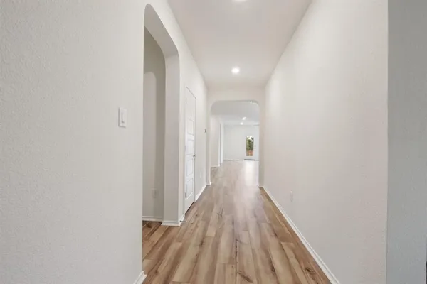 a view of a hallway with wooden floor