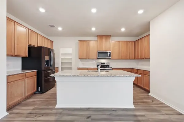 a view of empty room with wooden floor and ceiling fan