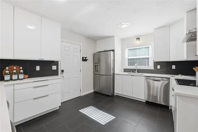 a kitchen with stainless steel appliances a refrigerator sink and cabinets
