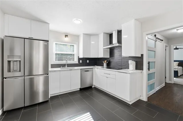 a kitchen with stainless steel appliances a refrigerator sink and cabinets