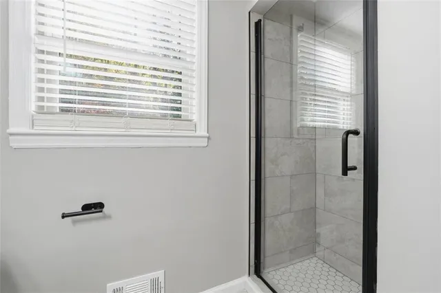 a bathroom with a window and a shower