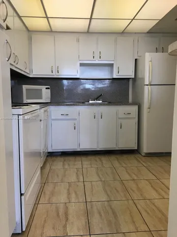 a kitchen with stainless steel appliances granite countertop a sink a stove a refrigerator a microwave and cabinets