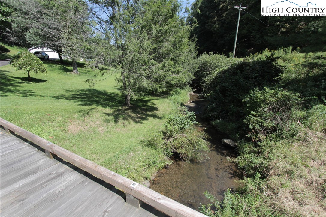 581 North Fork New River Road Lansing, NC 28643 - Photo 2 of 44 a view of a garden with a bench and trees