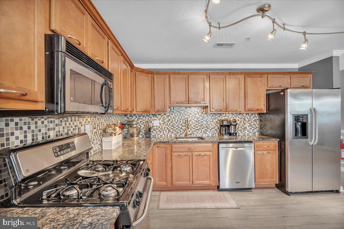 207 Redbud Lane, Unit 207 Mantua, NJ 08051 - Photo 11 of 22 a kitchen with stainless steel appliances granite countertop a stove a sink dishwasher a refrigerator and cabinets with wooden floor